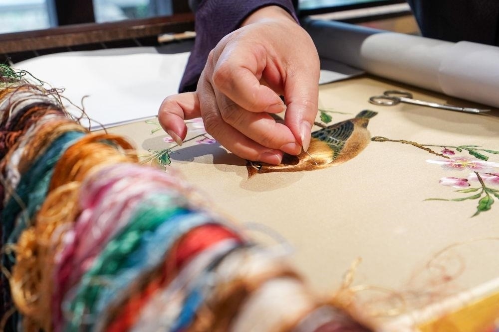 △2023年7月6日，盧建英在江蘇蘇州平江路的工作室內(nèi)刺繡。