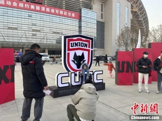 球迷們與隊(duì)徽合影。記者 卞立群 攝