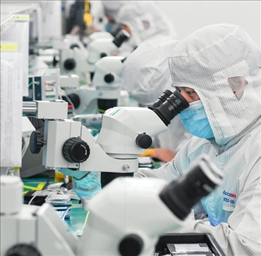 在位于武漢中國光谷的光電器件研發(fā)制造商——武漢光迅科技股份有限公司生產(chǎn)車間內(nèi)，技術(shù)人員在光模塊生產(chǎn)線作業(yè)（2023年4月11日攝）。程敏攝/本刊