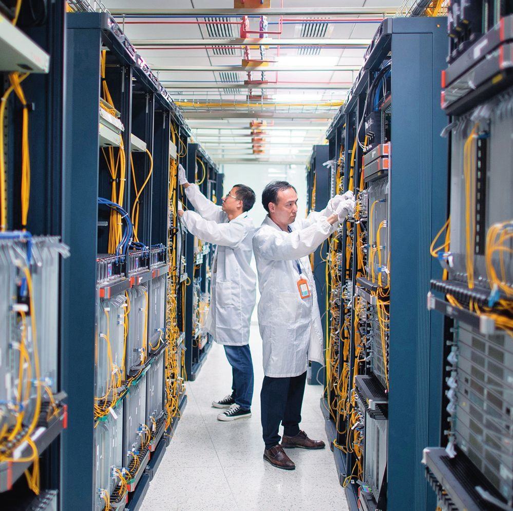 在位于武漢中國光谷的光電器件研發(fā)制造商——武漢光迅科技股份有限公司生產(chǎn)車間內(nèi)，技術(shù)人員在光模塊生產(chǎn)線作業(yè)（2023年4月11日攝）。程敏攝/本刊