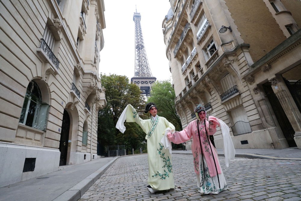 2023年9月13日，江蘇省演藝集團(tuán)昆劇院院長(zhǎng)施夏明（左）和江蘇省演藝集團(tuán)昆劇院國(guó)家一級(jí)演員孔愛萍在法國(guó)巴黎埃菲爾鐵塔附近參加昆曲快閃。新華社記者 高靜 攝