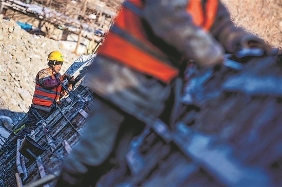 1月3日，房山區(qū)，工人正在雙泉河修筑堤壩。