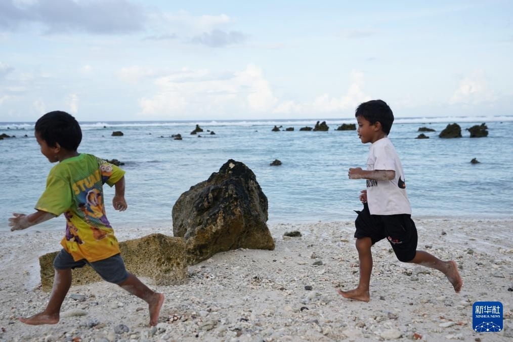 1月20日，兒童在瑙魯海邊嬉戲。新華社記者 王申 攝