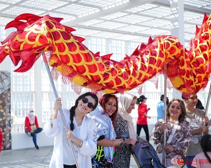 游客體驗(yàn)舞龍。 人民網(wǎng) 塔里克·易卜拉欣攝