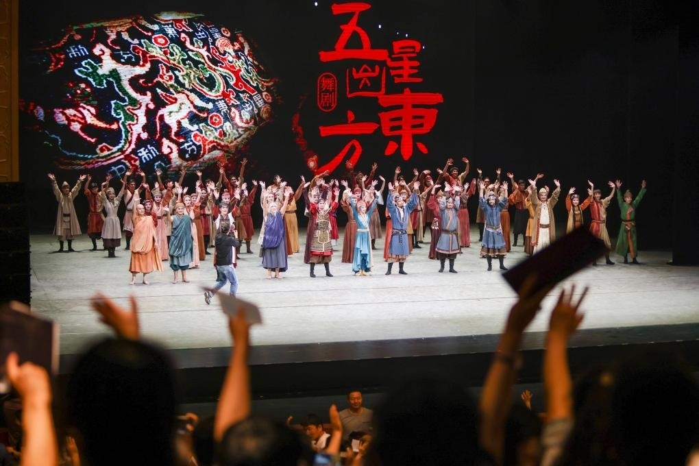 2023年7月31日，新疆和田地區(qū)新玉歌舞團在烏魯木齊京劇院演出舞劇《五星出東方》后和觀眾互相揮手致意。這場演出是第六屆中國新疆國際民族舞蹈節(jié)的參演劇目之一，曾榮獲國家“文華獎”等。新華社記者 郝昭 攝