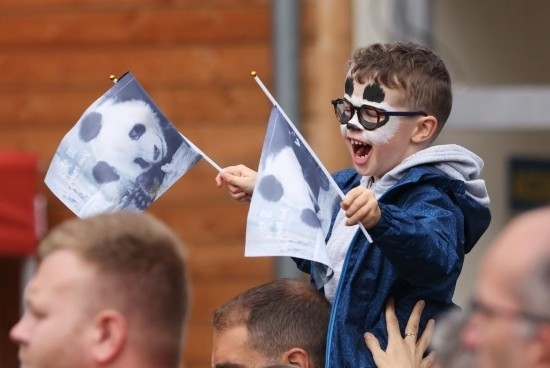  2023年7月26日，在法國(guó)圣艾尼昂市博瓦勒野生動(dòng)物園外，一名兒童等待送別熊貓“圓夢(mèng)”。新華社記者 高靜 攝