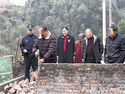  圖③：庭審結(jié)束后，在法官的見證下，陳某在院壩邊重新開鑿一條通道。