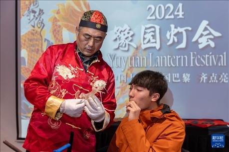 1月28日，在上海豫園舉行的民俗活動(dòng)上，美國馬斯卡廷中學(xué)學(xué)生在非遺傳承人的指導(dǎo)下吹糖偶。 新華社記者 王翔 攝