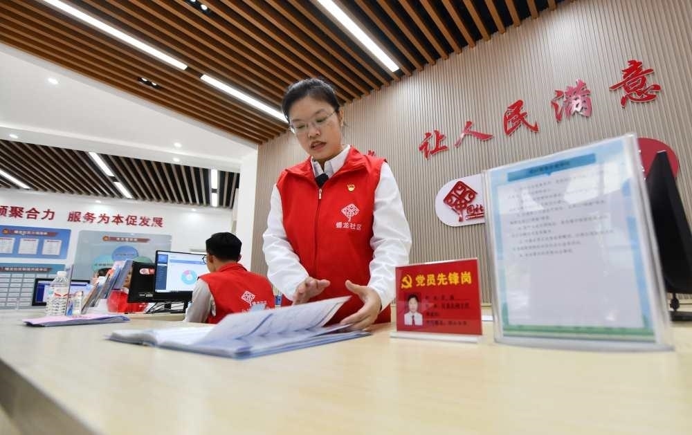 △2023年12月14日，廣西南寧市蟠龍社區(qū)，工作人員在為居民服務(wù)。