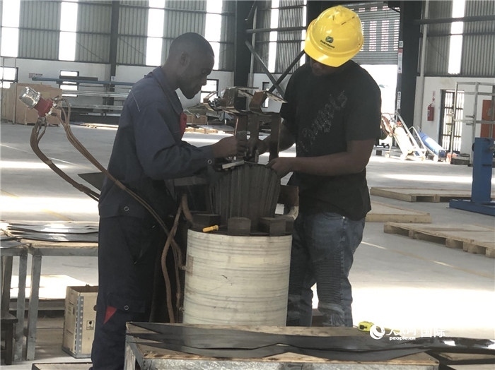 經(jīng)貿(mào)合作區(qū)廠(chǎng)房?jī)?nèi)，當(dāng)?shù)毓と苏诰o張作業(yè)。人民網(wǎng)記者 黃培昭攝