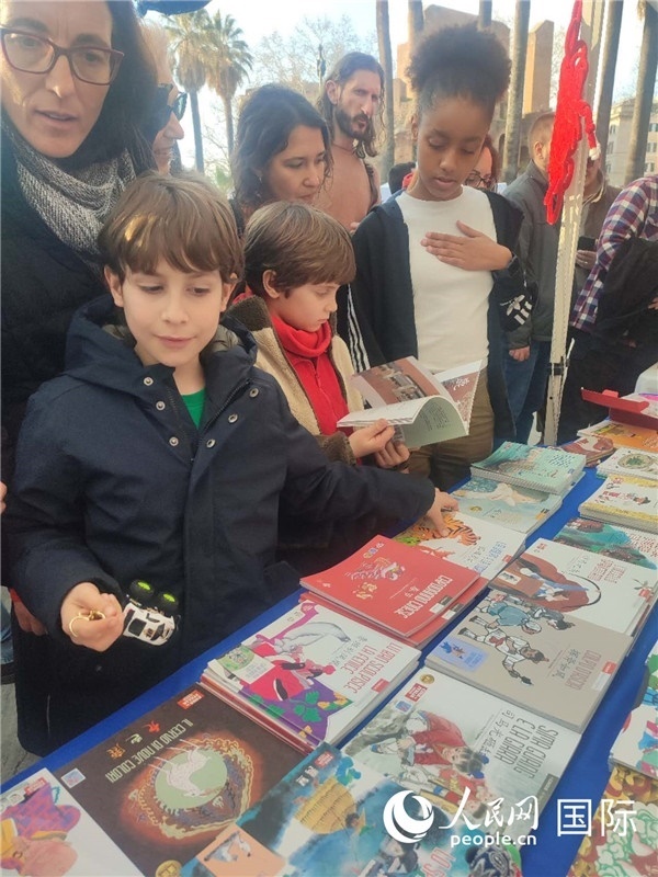 印刷精美的中國傳統(tǒng)文化叢書吸引了小游客的注意。人民網(wǎng)記者鄭彬攝