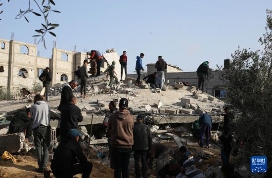 3月3日，在加沙地帶南部城市拉法，人們查看被以軍空襲破壞的建筑。新華社發(fā)（哈立德·奧馬爾攝）