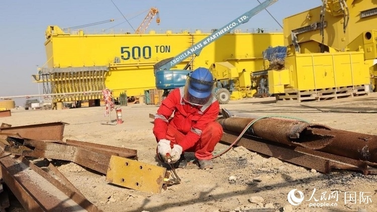 工人正在龍門(mén)吊吊裝現(xiàn)場(chǎng)切割金屬件。人民網(wǎng)記者管克江攝