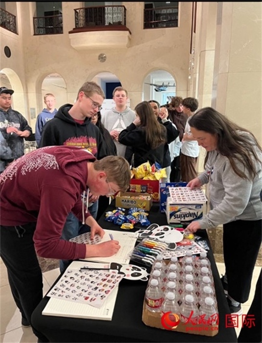 學(xué)生們出發(fā)前紛紛在留言簿留言。人民網(wǎng)記者 鄧圩攝