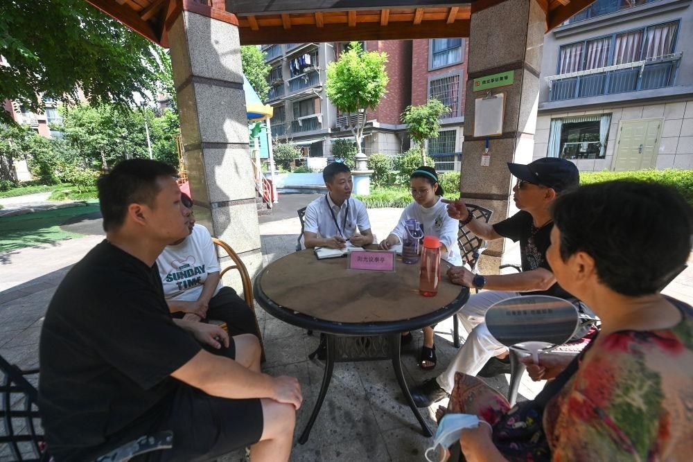 △2023年7月21日，在位于浙江杭州臨安區(qū)錦南街道水岸陽光小區(qū)的陽光議事廳，街道干部在聽取居民們反映的問題及意見。