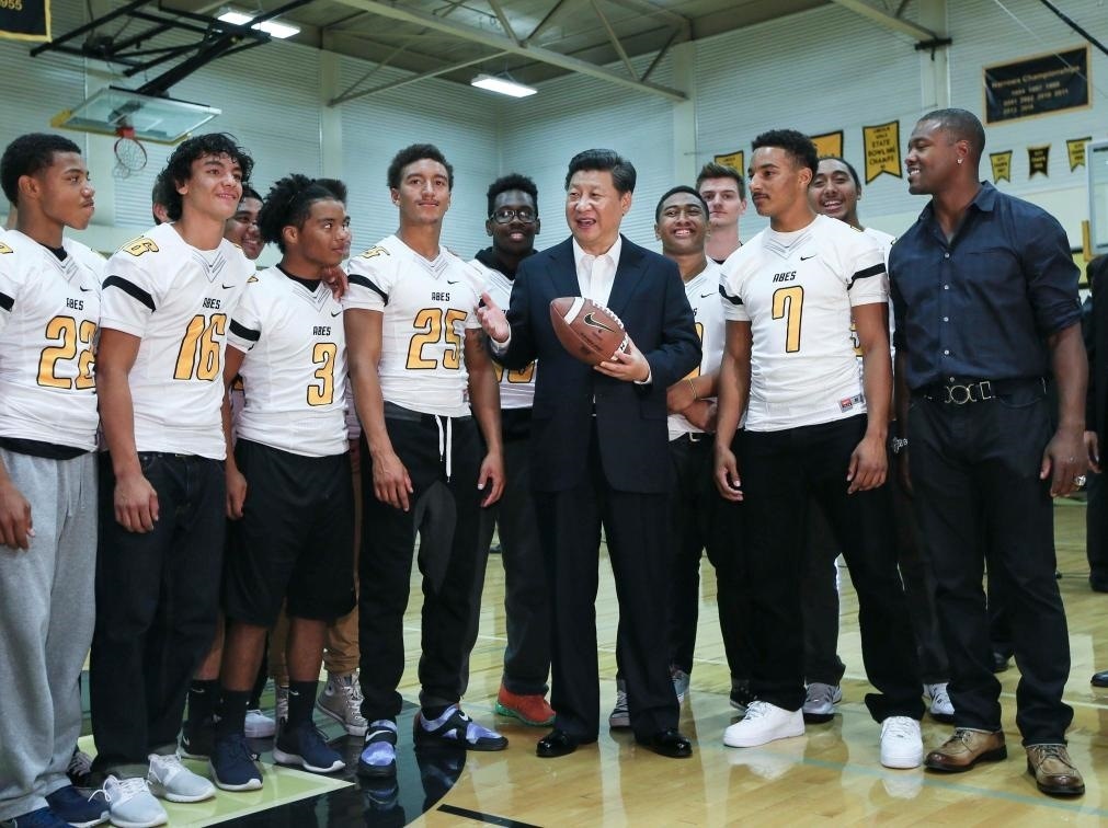 2015年9月23日，國家主席習(xí)近平參觀美國塔科馬市林肯中學(xué)。這是習(xí)近平在學(xué)校體育館，同上橄欖球訓(xùn)練課的學(xué)生們親切交談。新華社記者 蘭紅光 攝