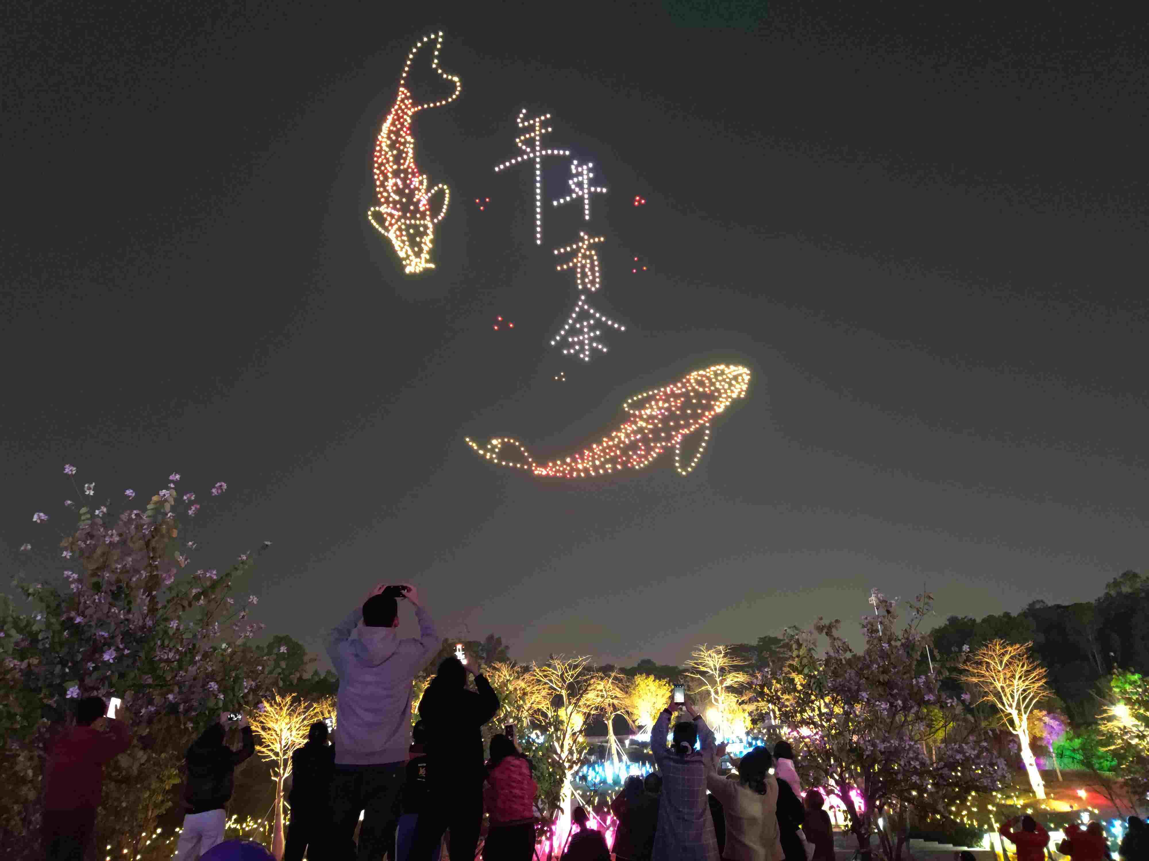 △ 2024年2月10日，深圳北站中心公園，春節(jié)主題無人機(jī)燈光秀引來眾多游客駐足觀看。