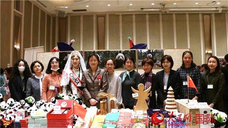 中國駐日本大使吳江浩夫人丁玥（左五）與使館人員在展位前合影留念。人民網(wǎng) 許可攝