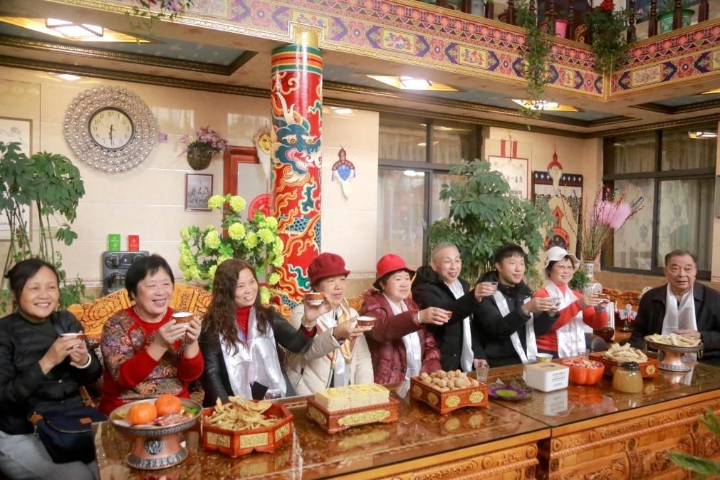 游客們?nèi)胱∶袼藓螅e杯共飲酥油茶。新華社記者 邱星翔 攝