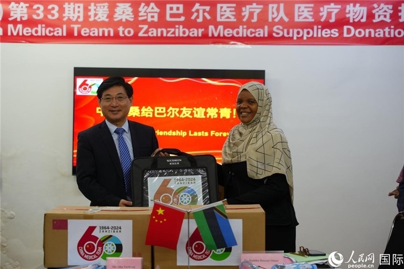 江蘇省蘇北人民醫(yī)院黨委書記束余聲捐贈物資與桑衛(wèi)生部首席秘書哈比巴。中國援桑醫(yī)療隊供圖