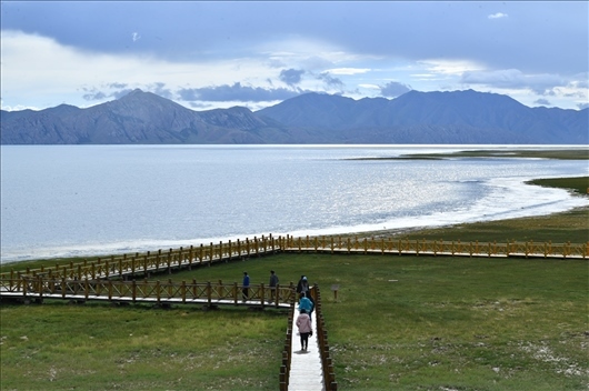 △ 游客行走在青?，敹嗫h冬格措納湖畔的木棧道上。