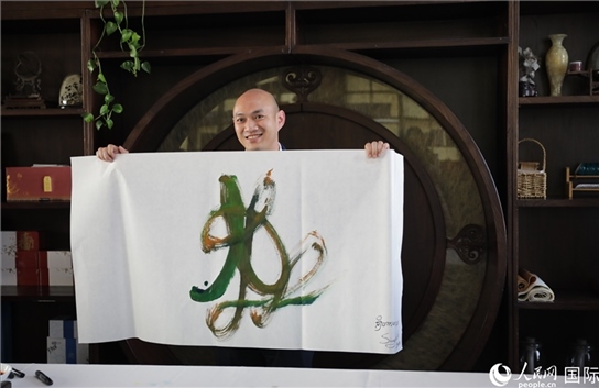 老撾駐華大使館三秘明君參加《五百筆·瀾湄合作》集體藝術(shù)創(chuàng)作。人民網(wǎng)王婧攝。