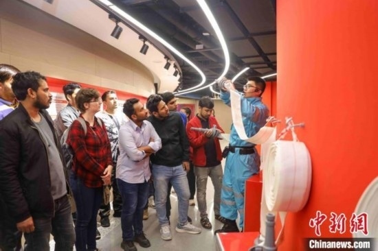 5月9日，工作人員指導(dǎo)留學(xué)生正確使用消防水帶。張鷹 攝