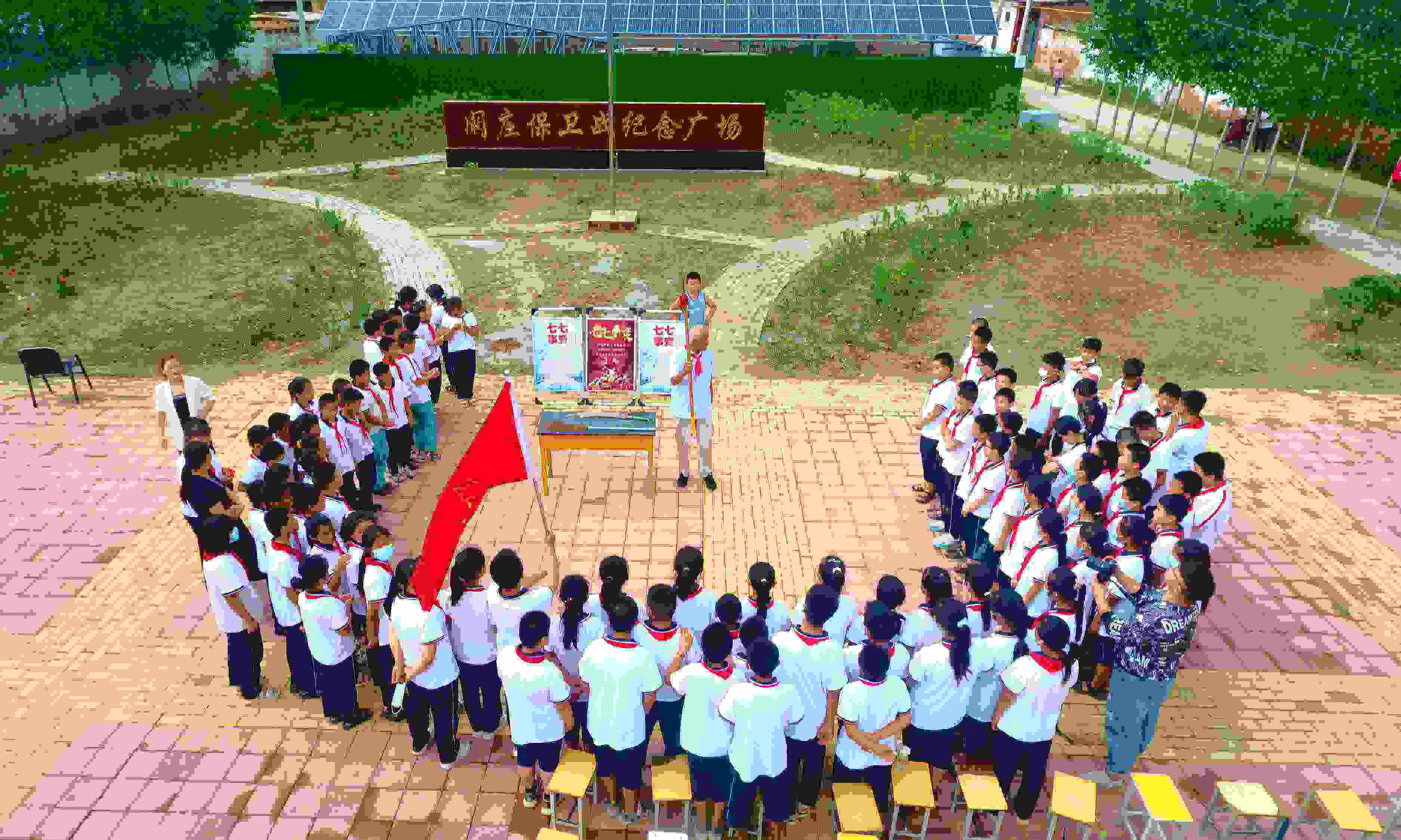 2022年7月6日，山東省聊城市，在茌平區(qū)菜屯鎮(zhèn)闞莊村的闞莊保衛(wèi)戰(zhàn)紀念廣場，闞莊保衛(wèi)戰(zhàn)親歷者王光木老人為小學(xué)生們講述抗戰(zhàn)故事，展示大刀、長矛。