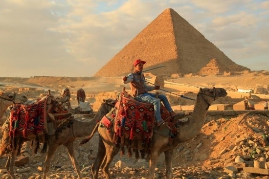 1月24日，商販騎駱駝離開埃及吉薩金字塔景區(qū)。新華社記者 隋先凱 攝
