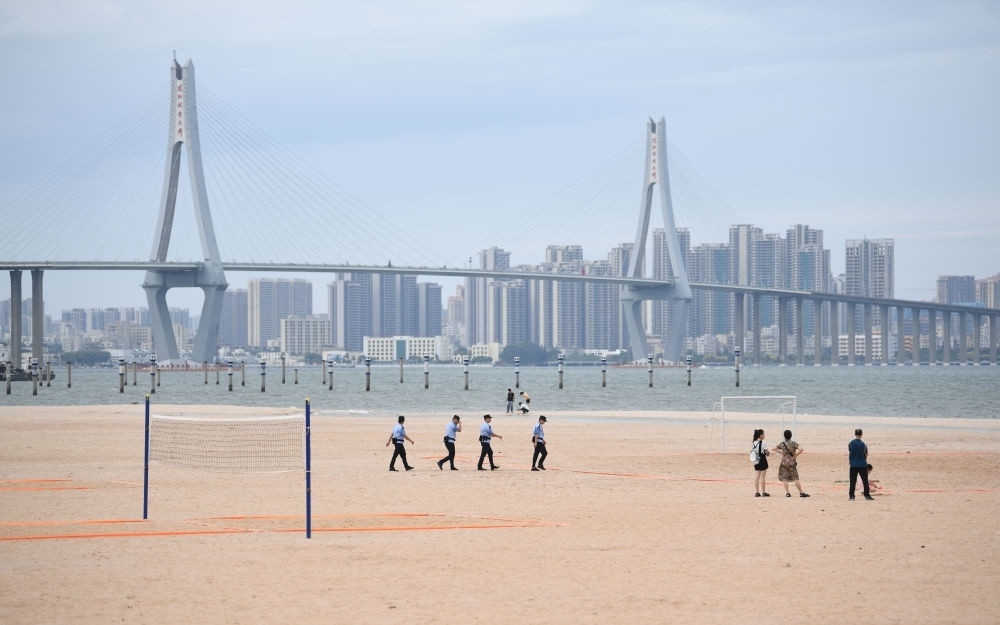 2023年7月17日，廣東湛江五環(huán)廣場的沙灘上，公安民警在執(zhí)勤巡邏。新華社記者 鄧華 攝