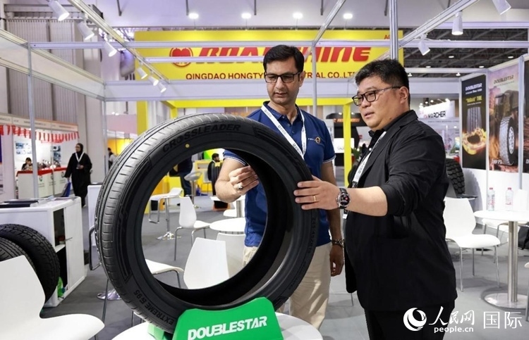 工作人員向客戶展示雙星電動汽車輪胎。和傳統(tǒng)汽車輪胎相比，電動汽車輪胎具有更高承載能力、更加靜音舒適、更好極速抓地、更低滾動阻力等特點。人民網(wǎng)記者 管克江攝