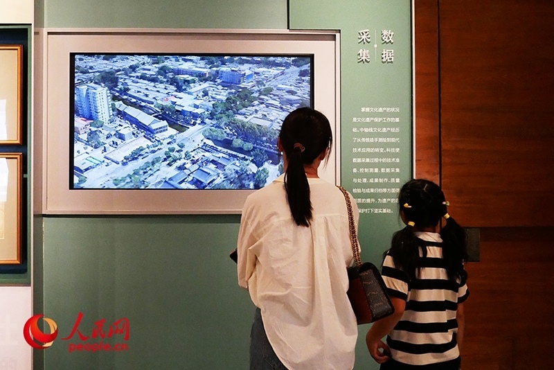 家長正在帶孩子參觀“輝煌中軸”專題展。人民網(wǎng)記者 韋衍行攝