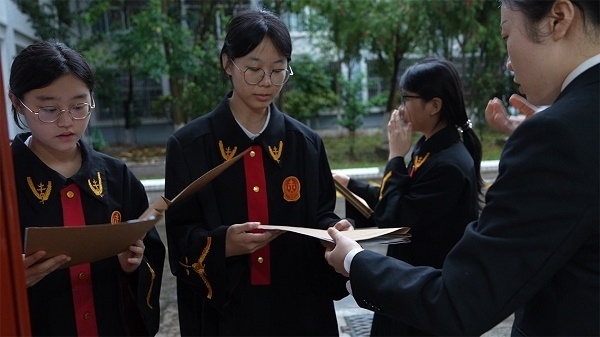 圖①：武平法院干警向?qū)W生分發(fā)道具卷宗。