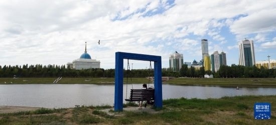 6月30日，一名女子在哈薩克斯坦首都阿斯塔納伊希姆河畔休息。新華社記者 王建華 攝