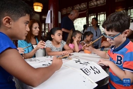 7月4日，在馬耳他桑塔露琪亞市的中國古典園林“靜園”，人們體驗中國書法。新華社發(fā)（喬納森·博格 攝）