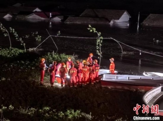  7月6日凌晨3時(shí)，在湖南岳陽華容縣團(tuán)洲垸洞庭湖一線堤防，救援人員剛剛完成一次救援任務(wù)，遠(yuǎn)處是被淹的民房。中新社記者 白祖偕 攝