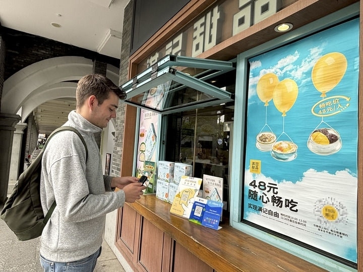 來(lái)自德國(guó)的留學(xué)生理查德在杭州西湖邊一家商鋪使用支付寶掃碼支付（2024年4月11日攝）。新華社發(fā)