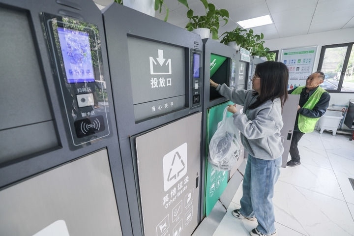 2024年4月10日，在浙江省湖州市吳興區(qū)飛英街道新華府小區(qū)內(nèi)，居民在垃圾分類智能系統(tǒng)的指導(dǎo)下進(jìn)行垃圾分類投放，居民的投放情況將實(shí)時(shí)匯總到智慧服務(wù)平臺，會有相應(yīng)的積分獎勵。新華社記者 徐昱 攝