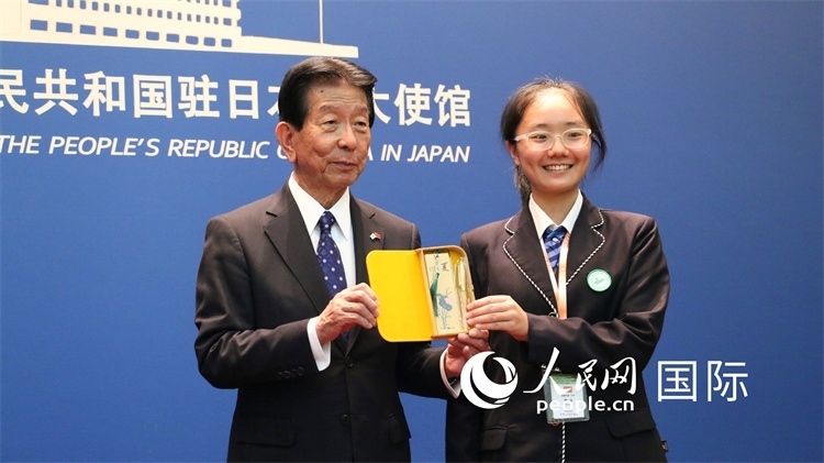 中國(guó)小大使向日本永旺1%俱樂部理事長(zhǎng)森美樹贈(zèng)送當(dāng)?shù)靥厣Y品。人民網(wǎng) 許可攝