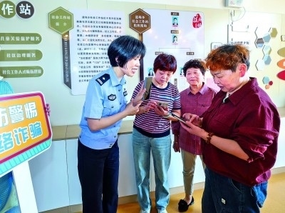 浙江湖州民警指導(dǎo)居民加入湖州“e企安”微信群，實(shí)時(shí)接收反詐信息。新華社發(fā)