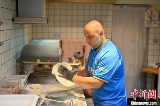 近日，韋榮耀在自家披薩小店內(nèi)忙活。俞靖 攝