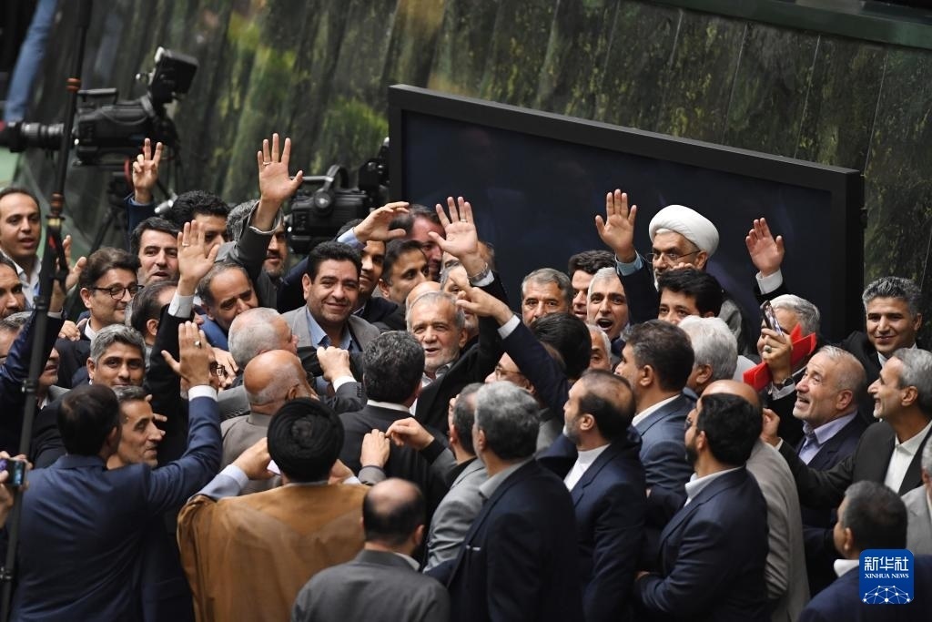 7月30日，在伊朗德黑蘭的伊朗議會(huì)，佩澤希齊揚(yáng)（中）離開(kāi)總統(tǒng)就職典禮現(xiàn)場(chǎng)時(shí)揮手致意。新華社記者 沙達(dá)提 攝