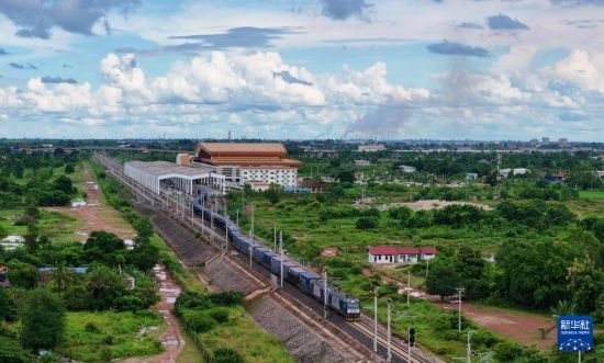 8月5日，由老撾籍火車司機(jī)獨(dú)立駕駛的滿載貨物的列車駛出萬象站，向中國昆明進(jìn)發(fā)（無人機(jī)照片）。新華社發(fā)（楊永全 攝）