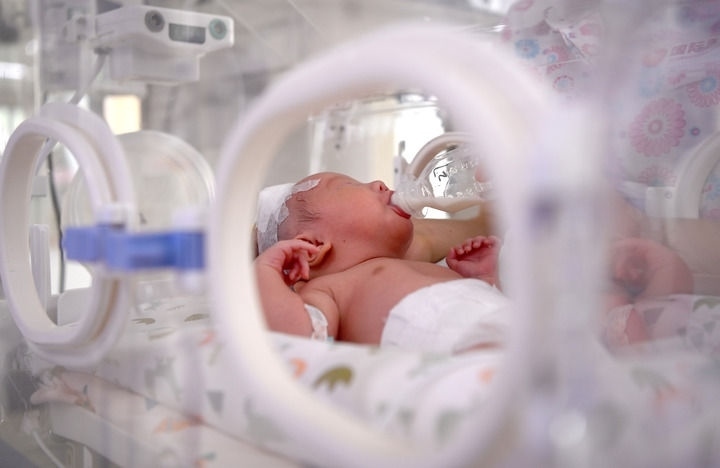 2024年6月1日，在西安國際醫(yī)學中心醫(yī)院新生兒科病房，護士為新生兒喂奶。 新華社記者 劉瀟 攝