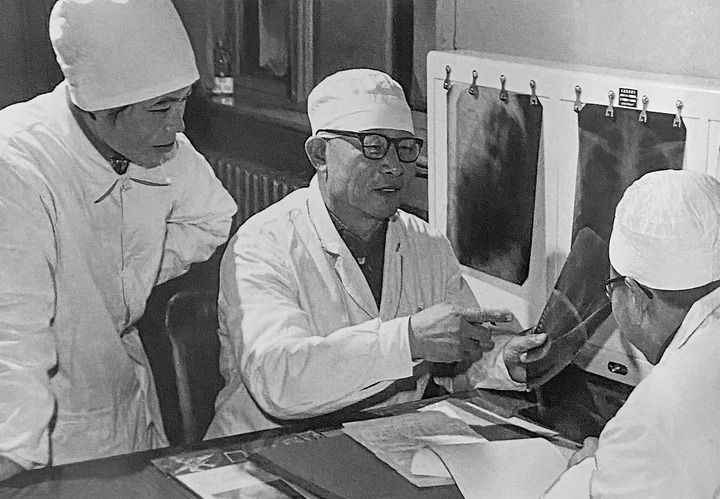 1980年1月16日，中日友好醫(yī)院首任院長辛育齡（中）在內(nèi)蒙古結(jié)核病院與胸外科醫(yī)師討論病例（翻拍照片）。 新華社發(fā)