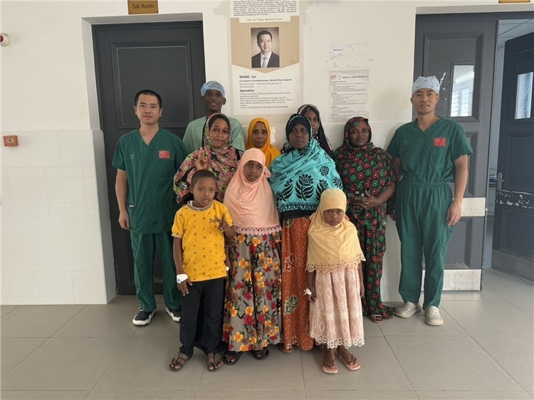 李廣（右一）和王林醫(yī)生與部分患者合影。中國援桑醫(yī)療隊供圖