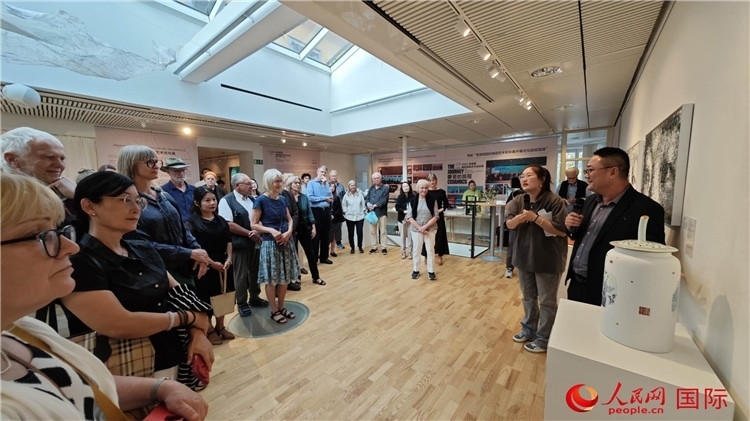 參展人、景德鎮(zhèn)陶瓷大學(xué)美術(shù)學(xué)院副院長(zhǎng)邵長(zhǎng)宗（右一）向來(lái)賓介紹參展作品。人民網(wǎng)記者 殷淼攝