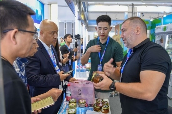 2023年8月23日，在第十四屆中國—東北亞博覽會(huì)東北亞商品館，俄羅斯參展商向參觀者介紹商品。