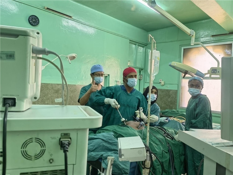 隊(duì)長蔣國慶（左一）關(guān)注當(dāng)?shù)蒯t(yī)生手術(shù)情況。中國援桑醫(yī)療隊(duì)供圖