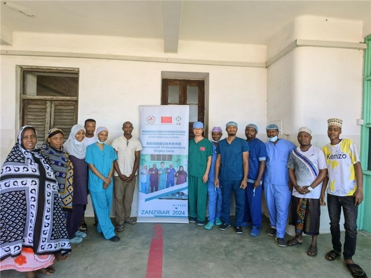 隊(duì)長蔣國慶（右七）和手術(shù)醫(yī)生、部分患者合影。中國援桑醫(yī)療隊(duì)供圖